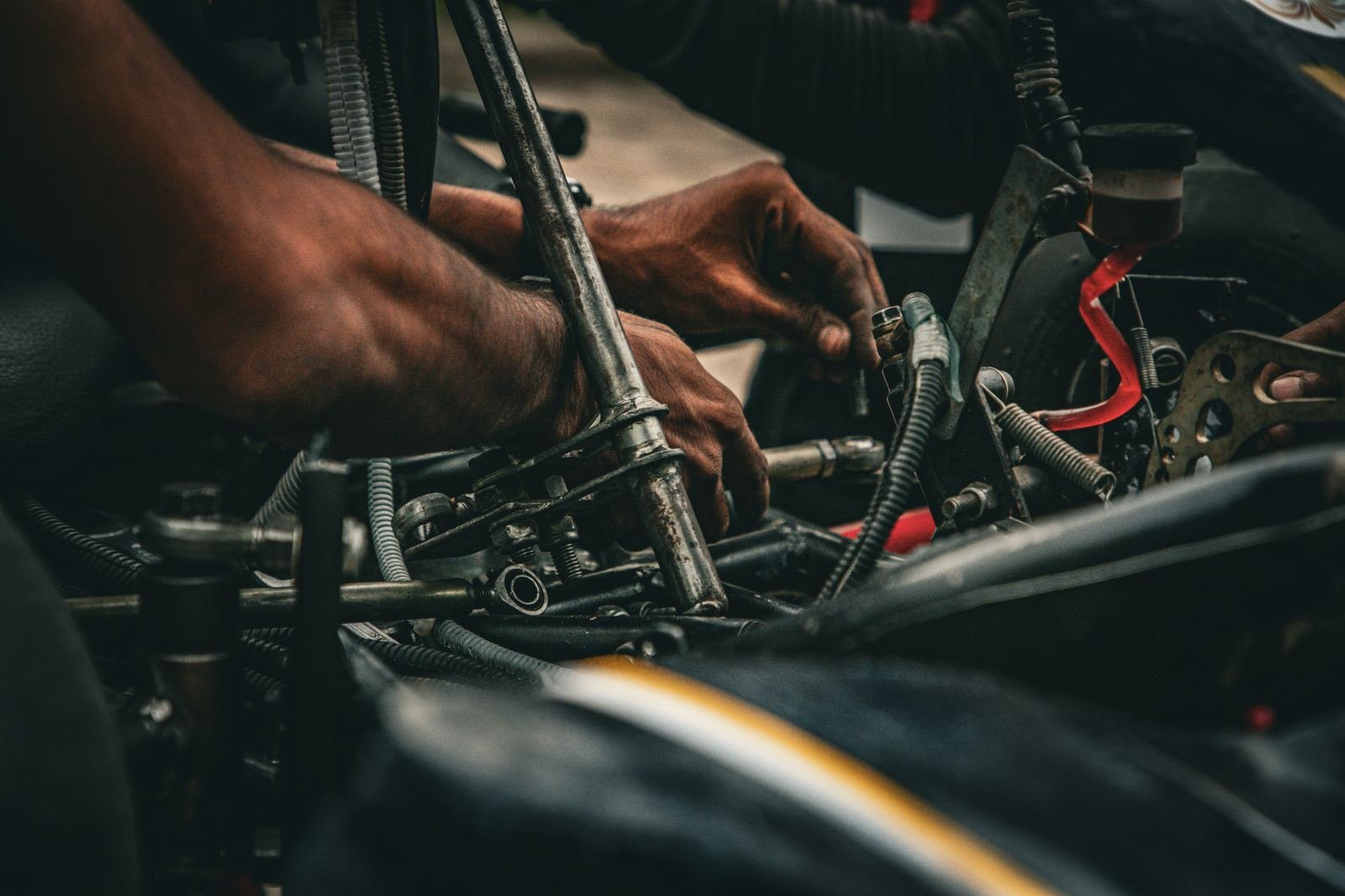 A mechanic’s hands working a wrench in an engine bay